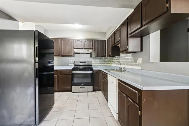 a kitchen with stainless steel appliances granite countertop a refrigerator and a stove