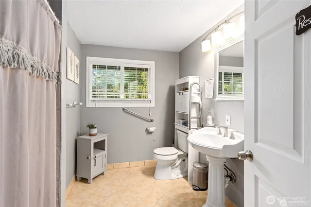 a bathroom with a toilet sink and mirror