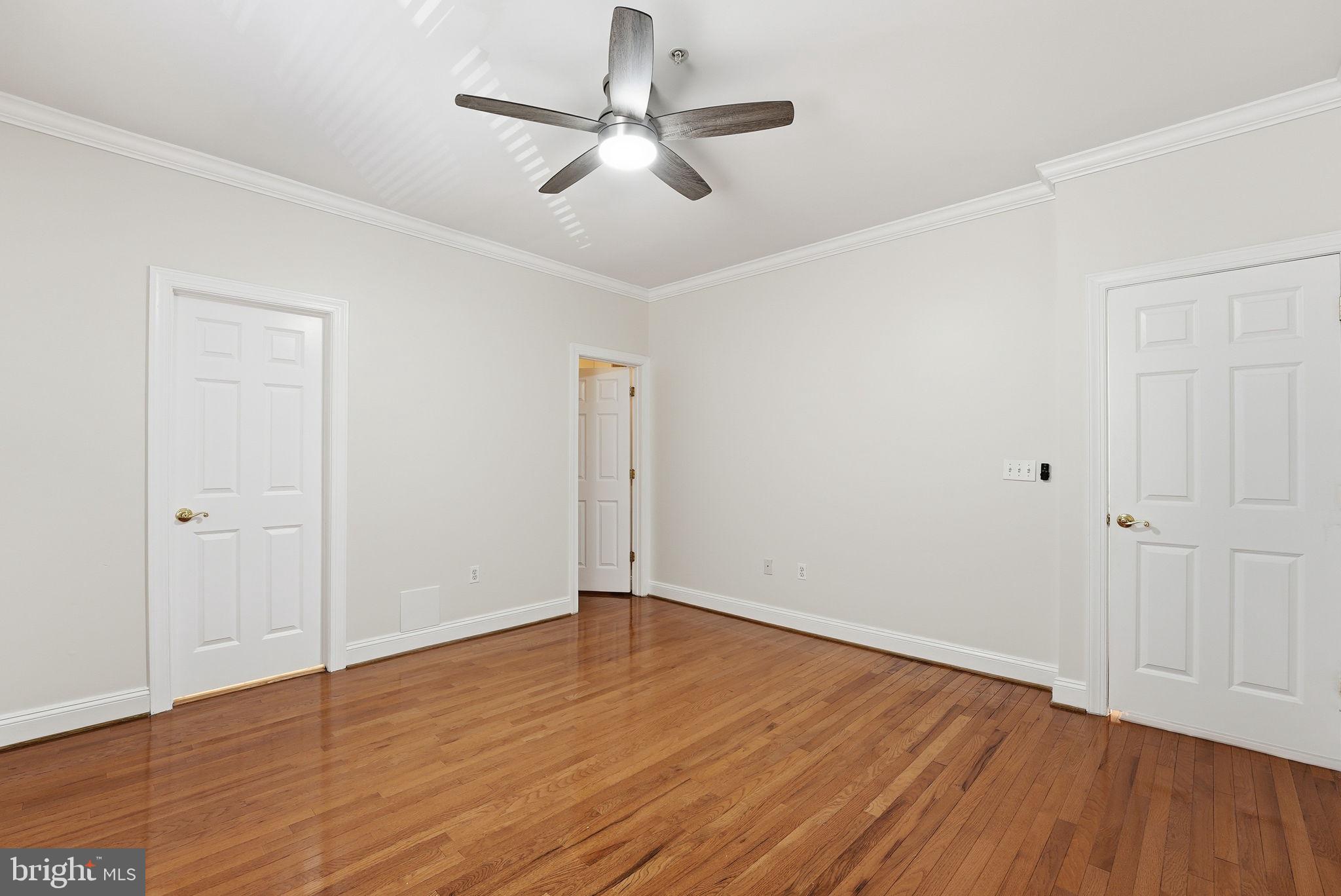 1229 12th Street Northwest, Unit 109 Washington, DC 20005 - Photo 14 of 23 an empty room with wooden floor ceiling fan and windows