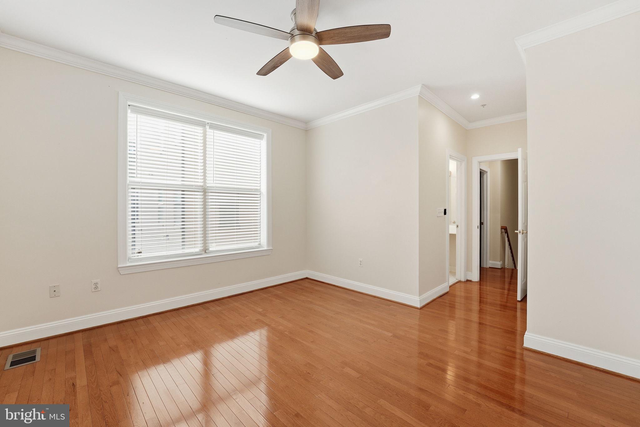 1229 12th Street Northwest, Unit 109 Washington, DC 20005 - Photo 20 of 23 a view of an empty room with a window and wooden floor