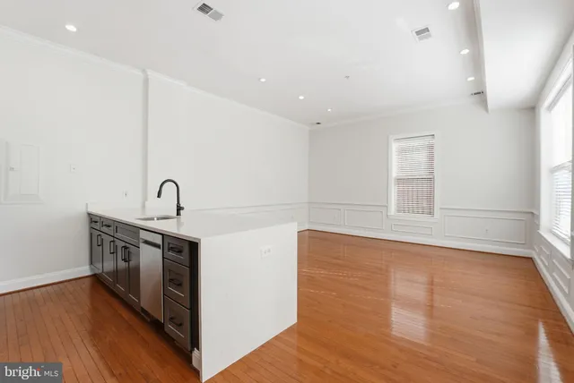 a view of a kitchen with sink and wooden floor