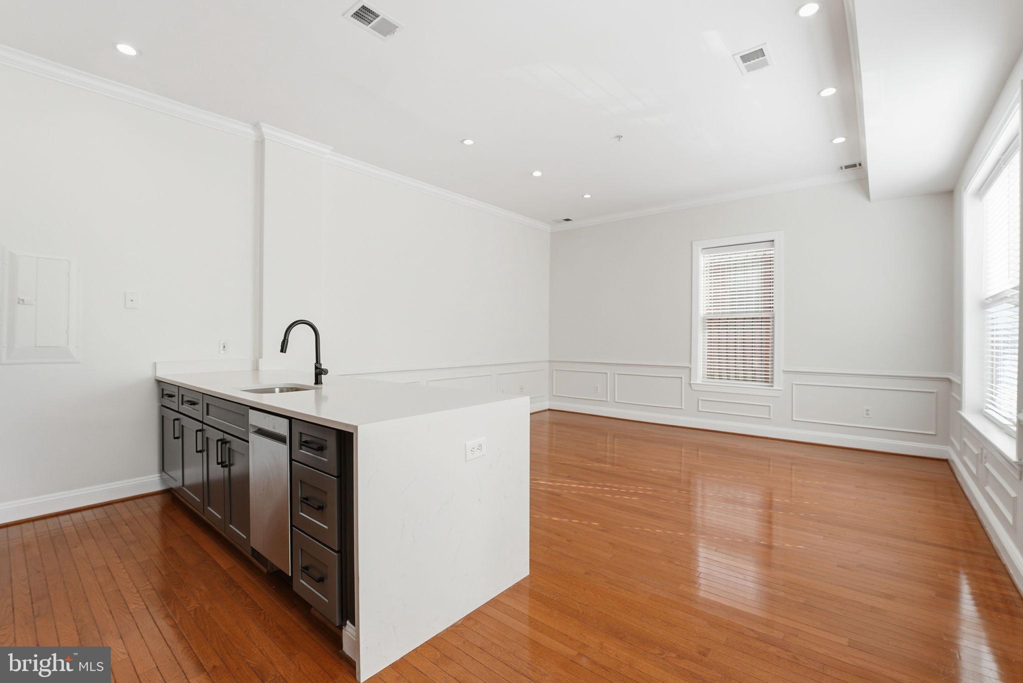 1229 12th Street Northwest, Unit 109 Washington, DC 20005 - Photo 4 of 23 a view of a kitchen with sink and wooden floor