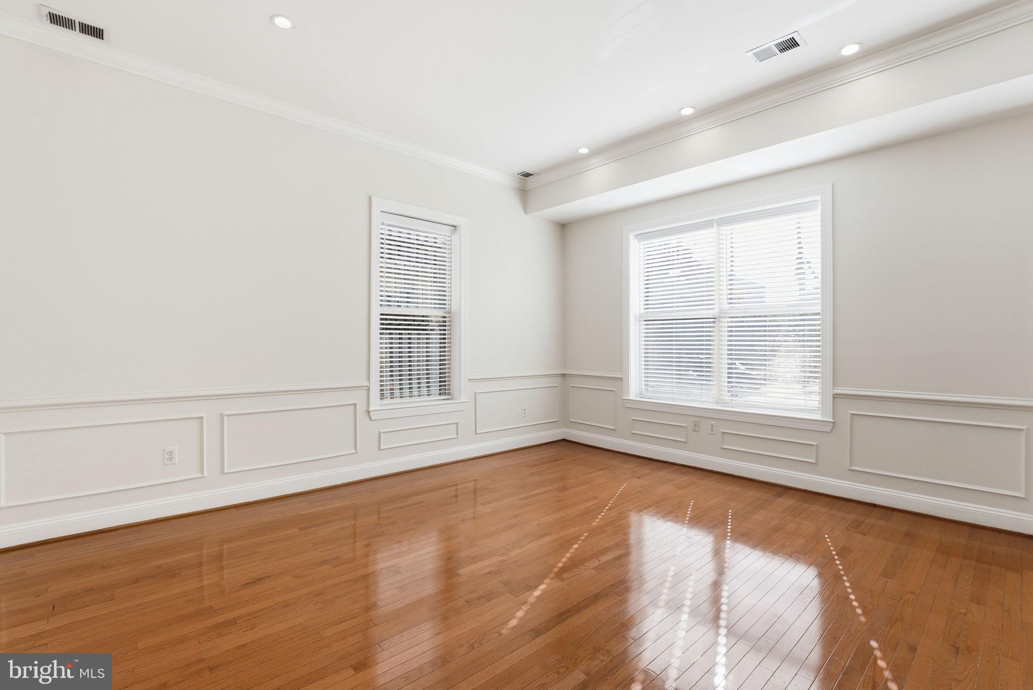 1229 12th Street Northwest, Unit 109 Washington, DC 20005 - Photo 7 of 23 an empty room with wooden floor and windows