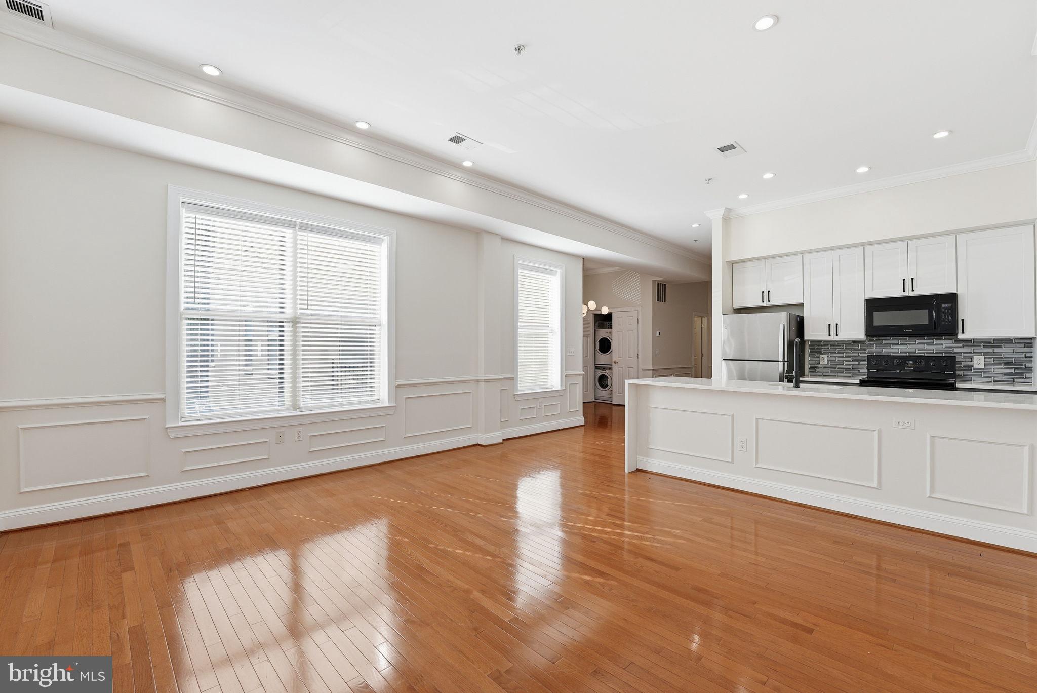1229 12th Street Northwest, Unit 109 Washington, DC 20005 - Photo 8 of 23 a large white kitchen with granite countertop a large counter top stainless steel appliances and cabinets