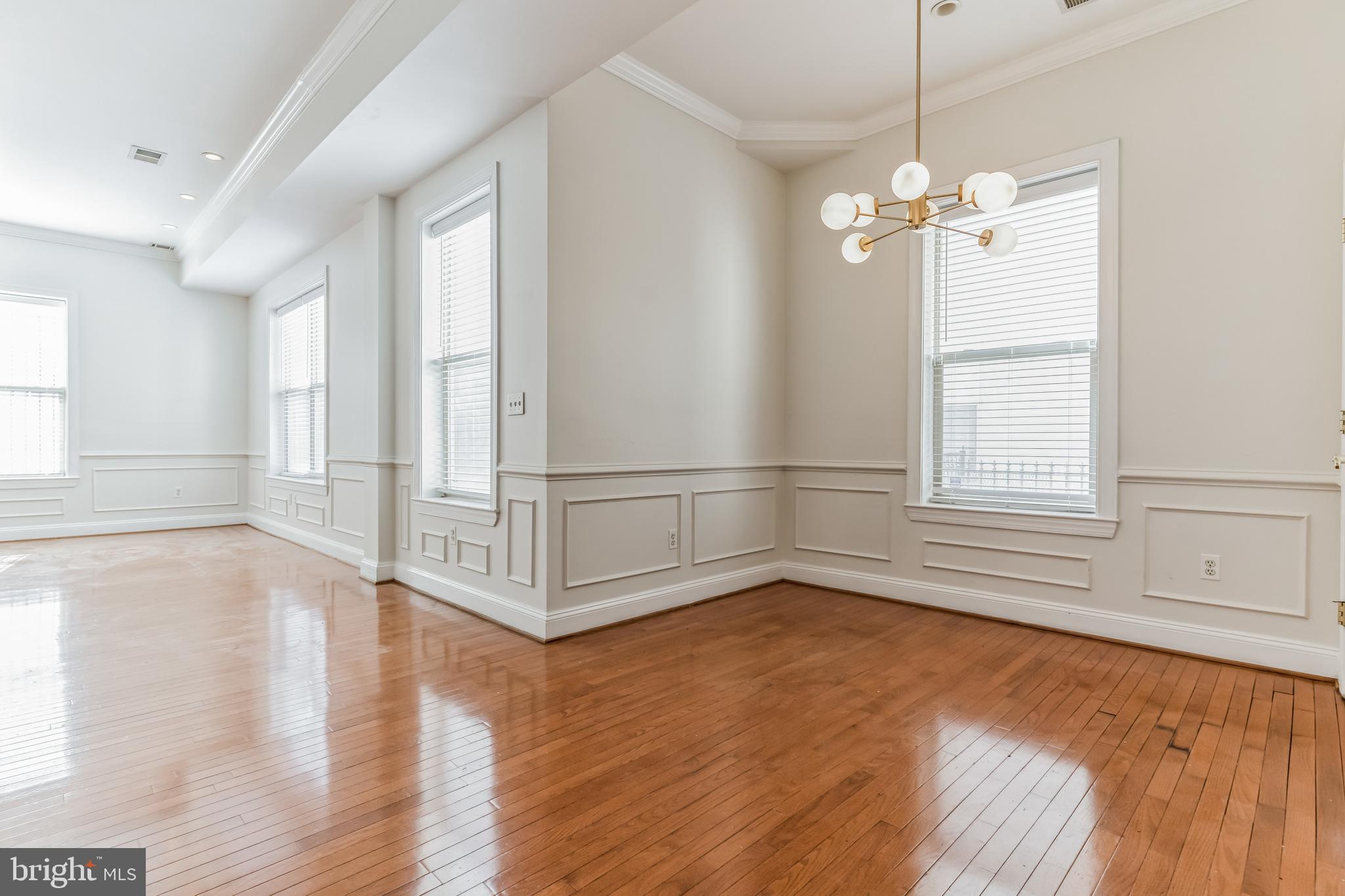 1229 12th Street Northwest, Unit 109 Washington, DC 20005 - Photo 9 of 23 a view of empty room with wooden floor and fan