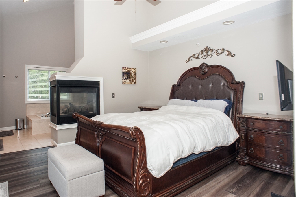 1501 Old Bridge Lane, Unit 1501 Bellingham, MA 02019 - Photo 24 of 42 a bedroom with bed and a fireplace