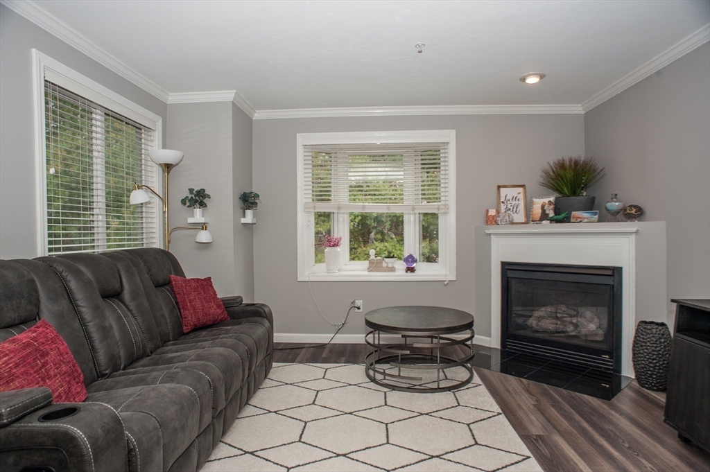 1501 Old Bridge Lane, Unit 1501 Bellingham, MA 02019 - Photo 10 of 42 a living room with furniture and a fireplace