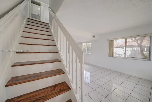 an empty room with windows and ceiling fan