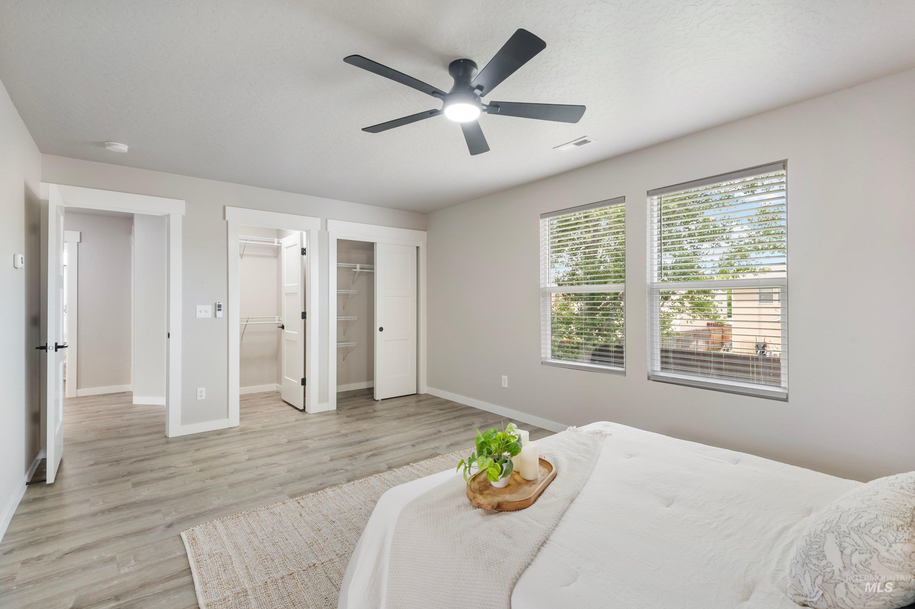 16759 Abram Avenue Caldwell, ID 83607 - Photo 21 of 33 Spacious room featuring wood-finish flooring, two windows with blinds, and a contemporary ceiling fan