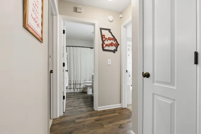 a view of a hallway with wooden floor and closet