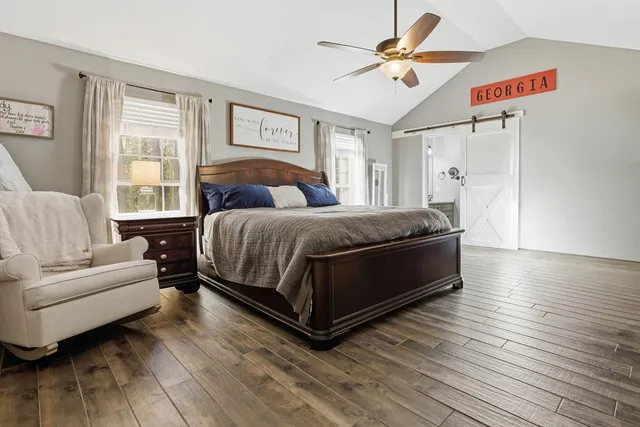 a bedroom with a bed couch and a large window