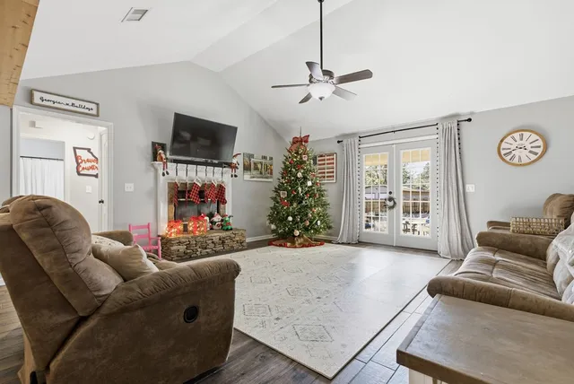 a living room with furniture a flat screen tv and a clock