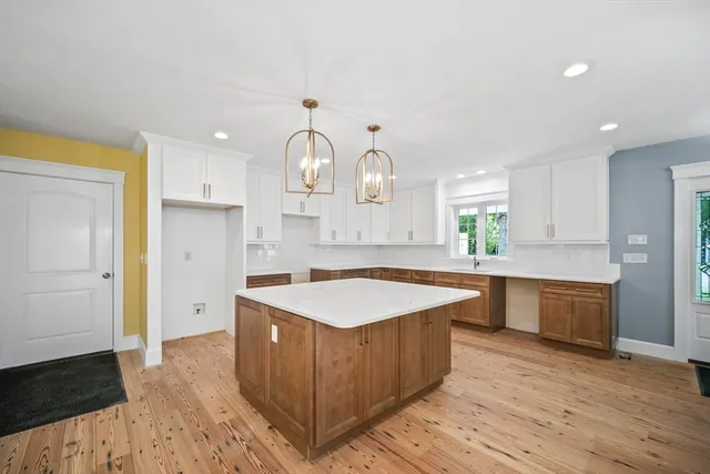 a kitchen with stainless steel appliances granite countertop a sink a stove and a wooden floors
