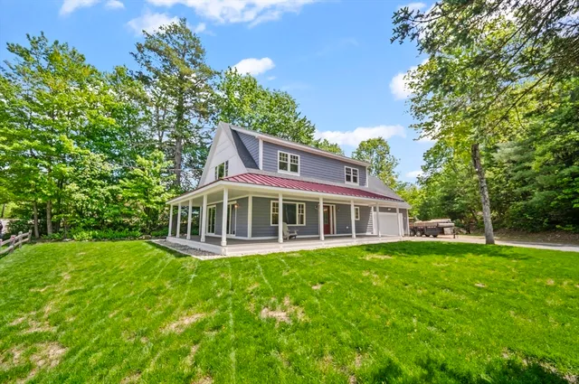 a view of a house with a yard and sitting area