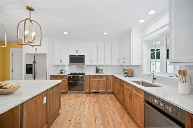 a kitchen with stainless steel appliances granite countertop a sink dishwasher stove top oven and refrigerator