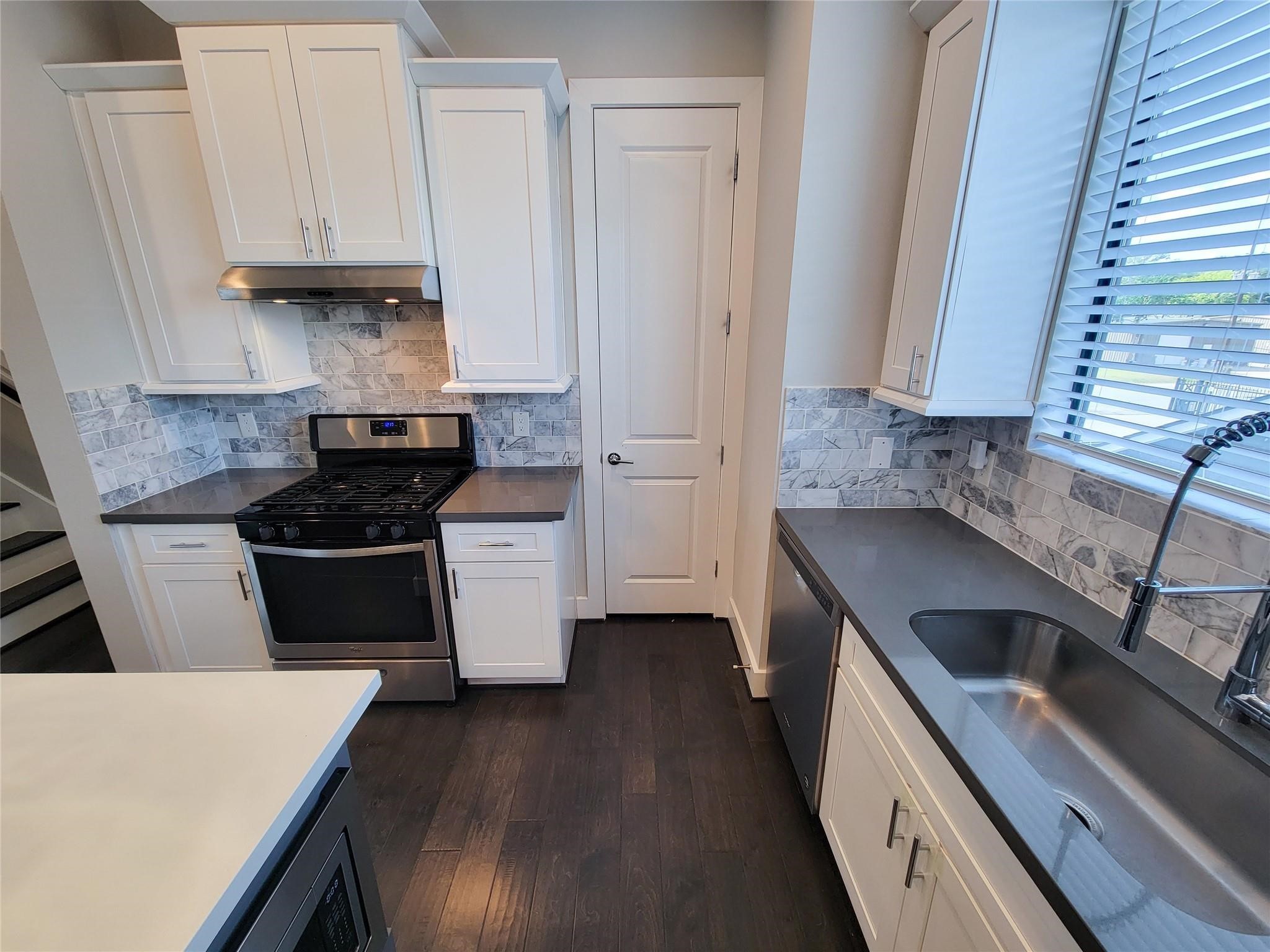 10806 Warwana Road, Unit C Houston, TX 77043 - Photo 5 of 9 a kitchen with granite countertop a sink a stove and cabinets