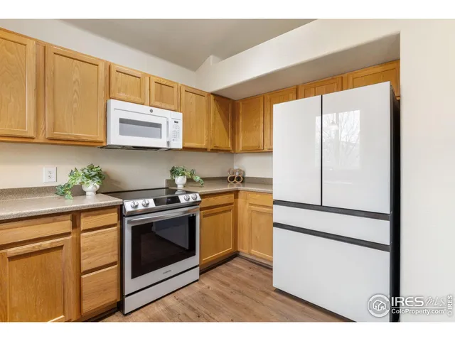 a kitchen with stainless steel appliances granite countertop a refrigerator sink stove and microwave