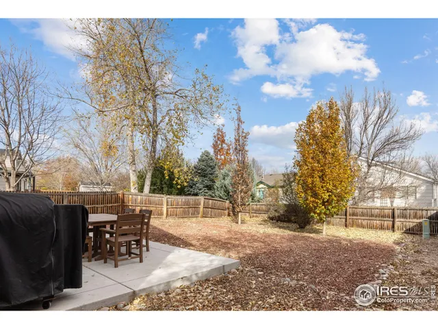 a backyard of a house with table and chairs