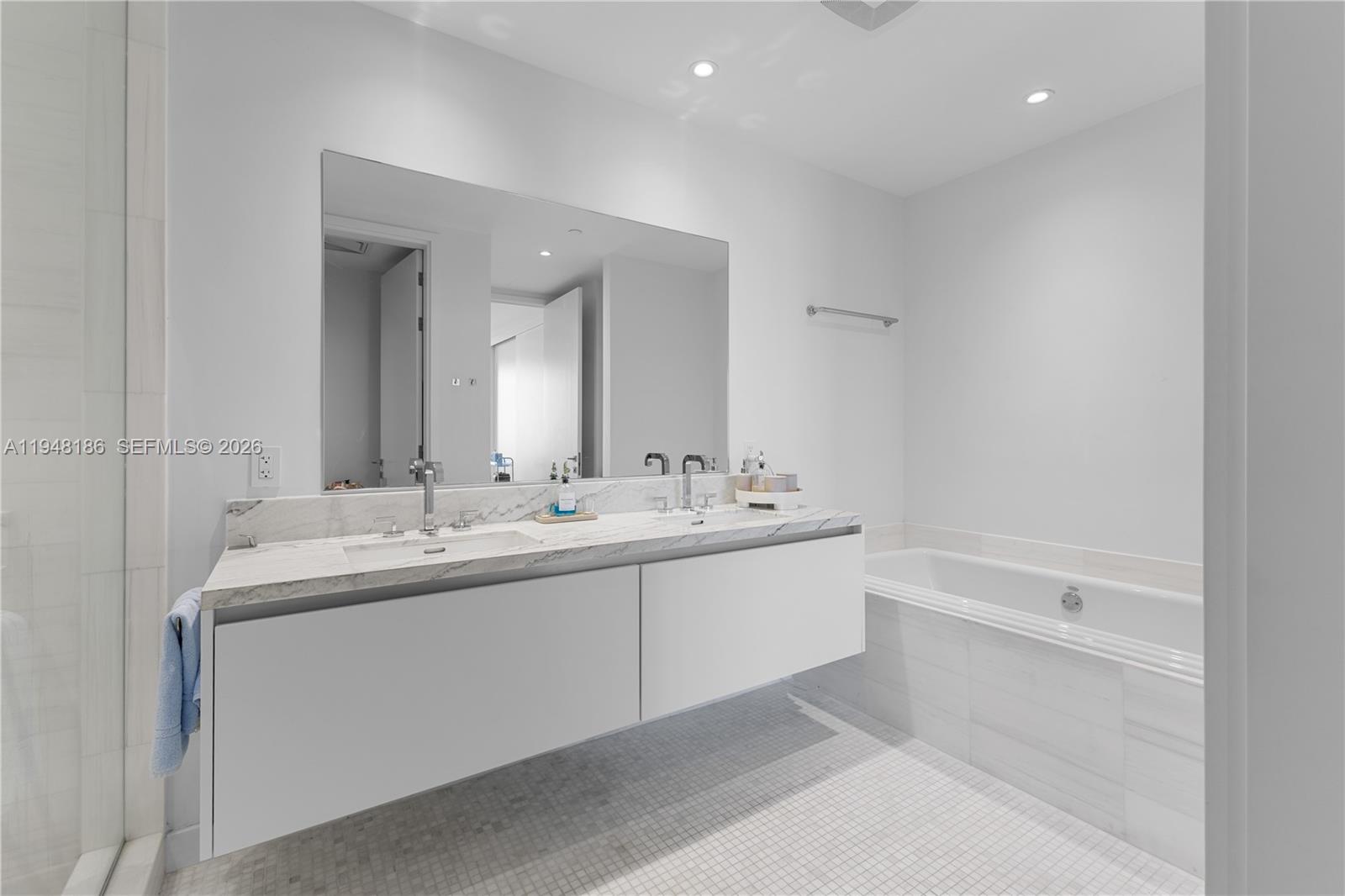 700 Northeast 26th Terrace, Unit 4701 Miami, FL 33137 - Photo 21 of 33 a bathroom with a tub a double vanity sink and mirror