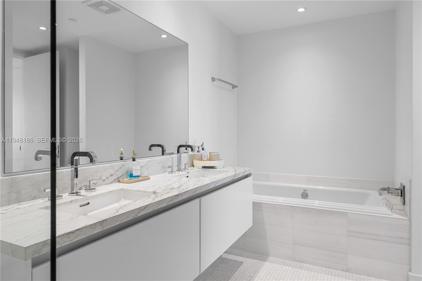 700 Northeast 26th Terrace, Unit 4701 Miami, FL 33137 - Photo 22 of 33 a bathroom with a granite countertop sink and a mirror