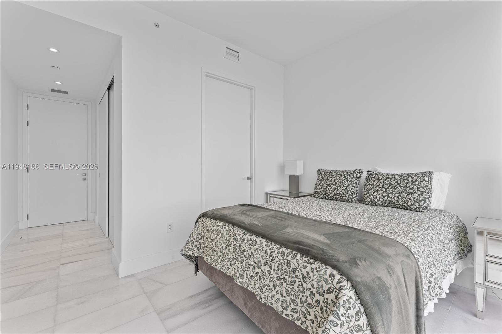 700 Northeast 26th Terrace, Unit 4701 Miami, FL 33137 - Photo 26 of 33 a bedroom with a bed and a painting on the wall