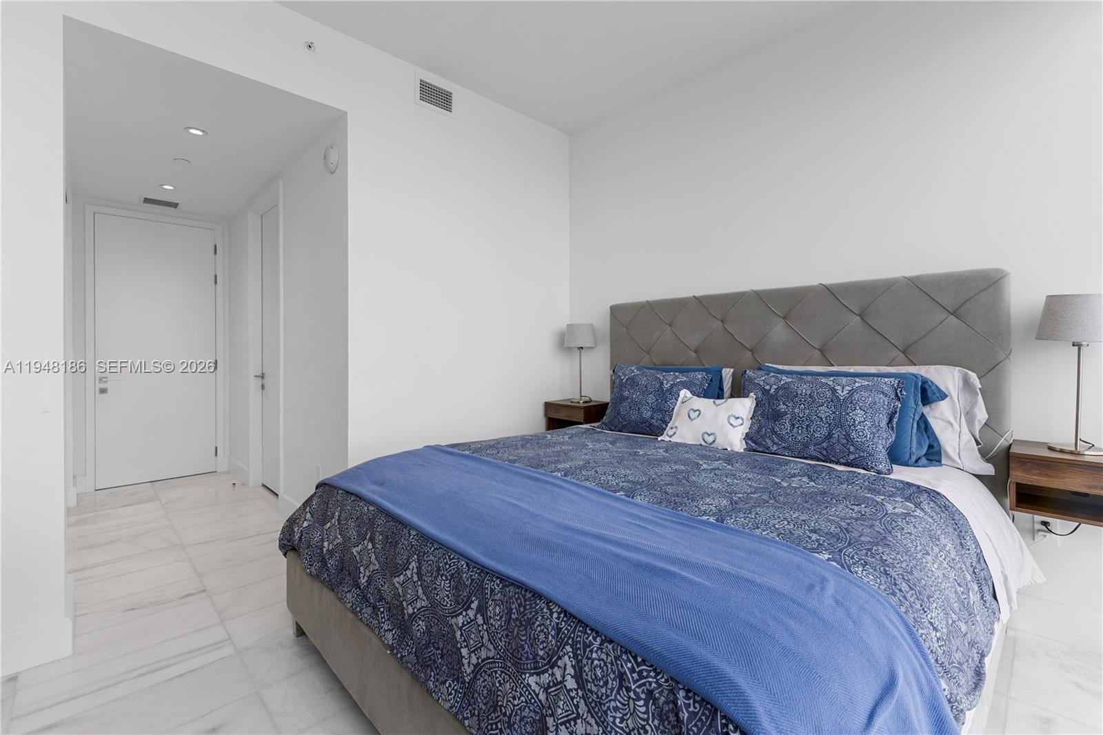 700 Northeast 26th Terrace, Unit 4701 Miami, FL 33137 - Photo 28 of 33 a bedroom with a bed and a mirror