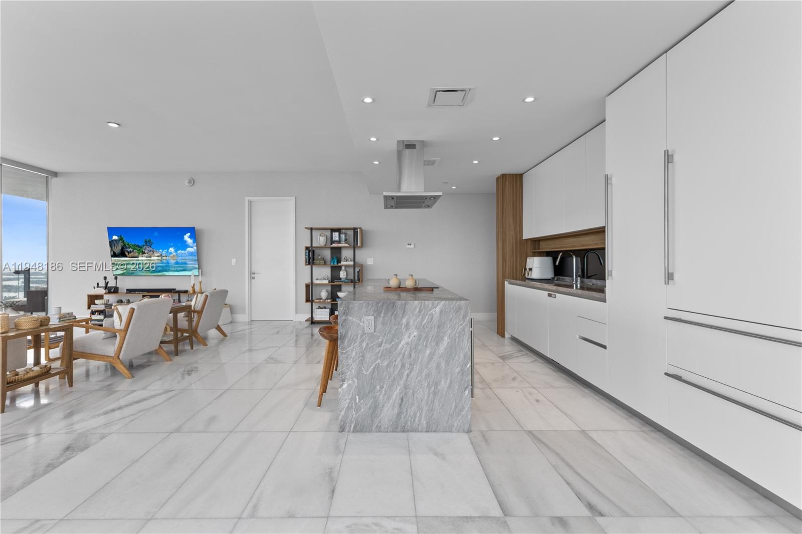 700 Northeast 26th Terrace, Unit 4701 Miami, FL 33137 - Photo 10 of 33 a living room with furniture a flat screen tv and kitchen view