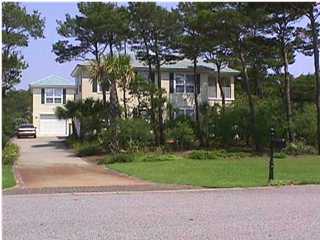 a front view of a house with a garden and trees