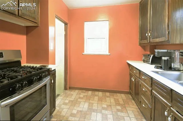 a kitchen with granite countertop wooden cabinets and a stove top oven