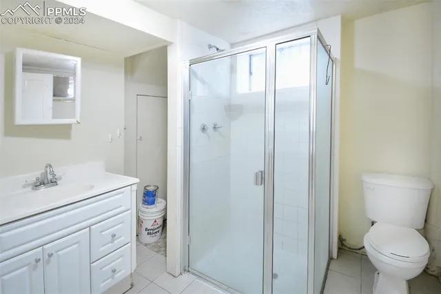 a view of a backyard with large trees and wooden fence