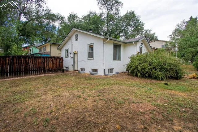 a view of a house with a yard and wooden fence