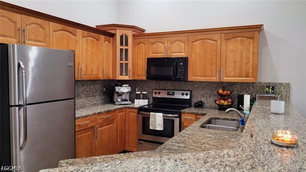 152 Pullman Street Lehigh Acres, FL 33974 - Photo 4 of 15 a kitchen with stainless steel appliances granite countertop a refrigerator stove top oven a sink and dishwasher