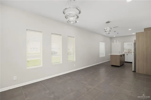 a view of a kitchen with refrigerator and windows