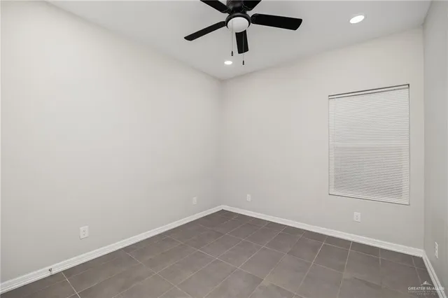 an empty room with a window and a fan