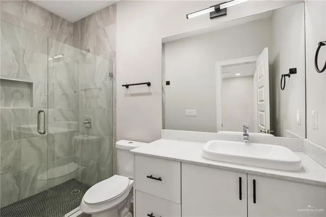 a bathroom with a sink a toilet and shower