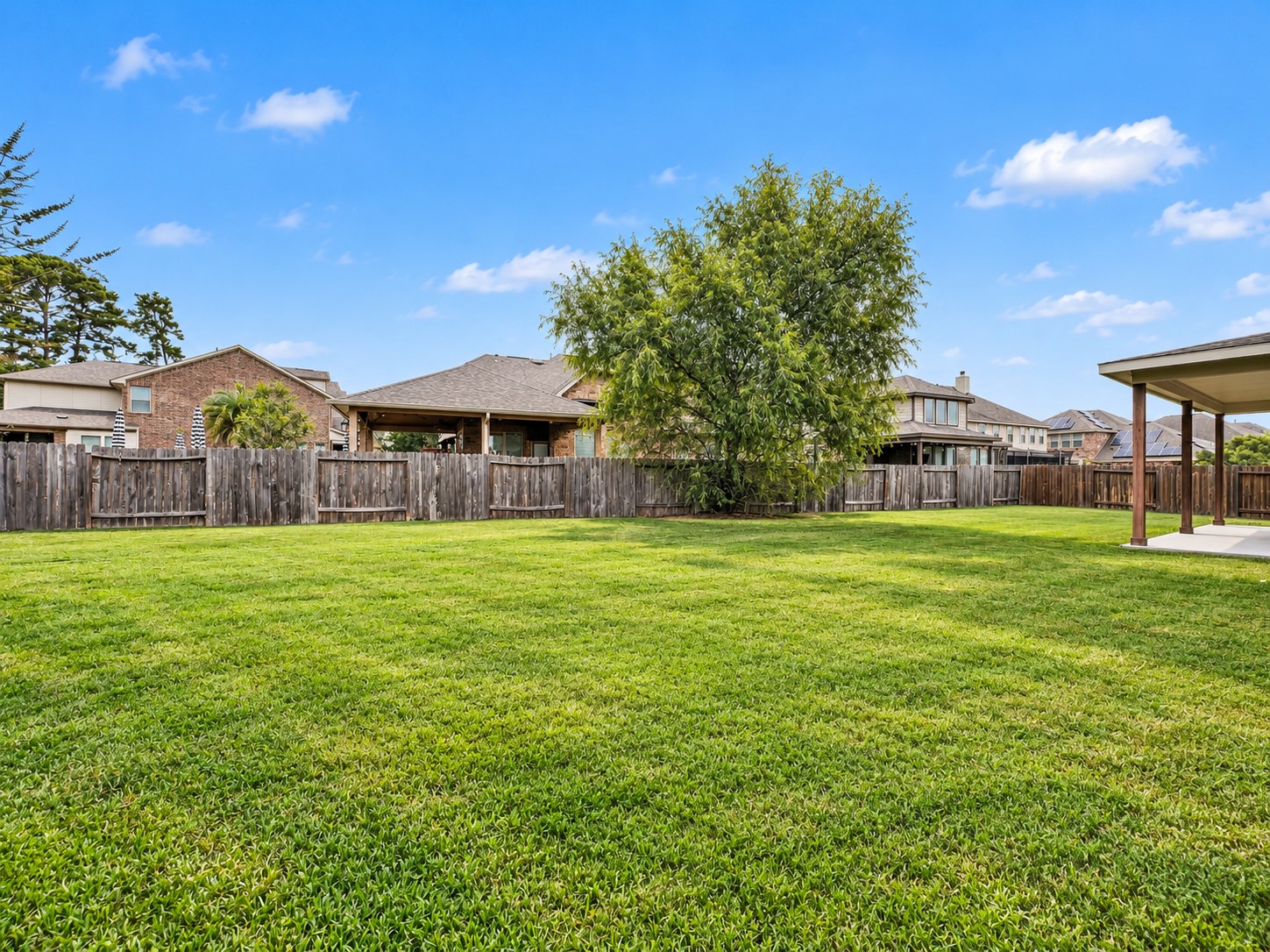 9626 Invergarry Way Tomball, TX 77375 - Photo 42 of 43 Wide view showcases the generous backyard with mature shade tree, established lawn, and wood privacy fencing.