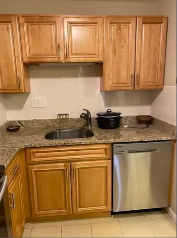 a kitchen with granite countertop white cabinets and stainless steel appliances