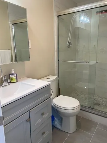 a bathroom with a sink a toilet and shower
