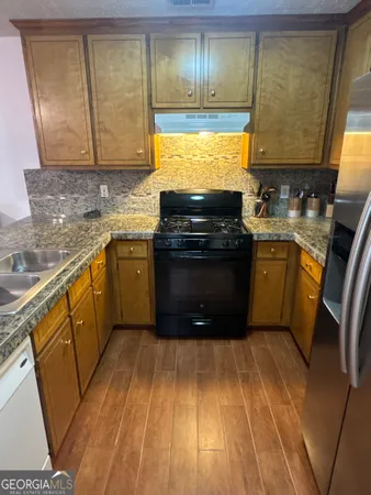 a kitchen with stainless steel appliances granite countertop a stove a sink and a microwave