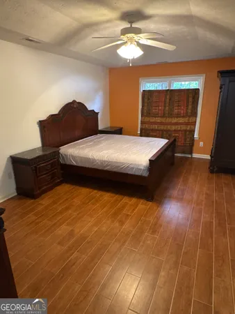 a bedroom with a bed dresser and a window