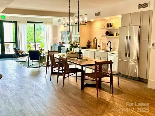 a dining hall with stainless steel appliances kitchen island granite countertop furniture and a fireplace