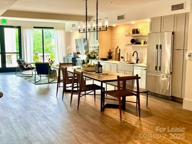 a dining hall with stainless steel appliances kitchen island granite countertop furniture and a fireplace