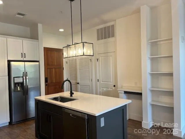 a kitchen with kitchen island a sink appliances and cabinets