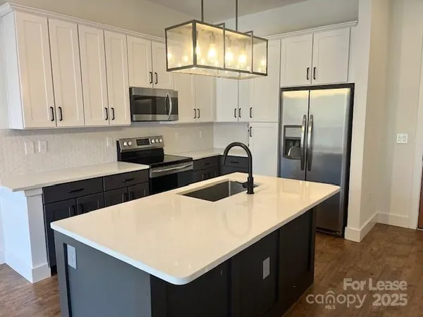 a kitchen with stainless steel appliances a microwave a sink a stove and refrigerator