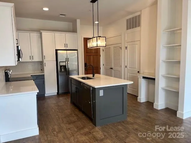 a kitchen with stainless steel appliances a stove refrigerator and cabinets