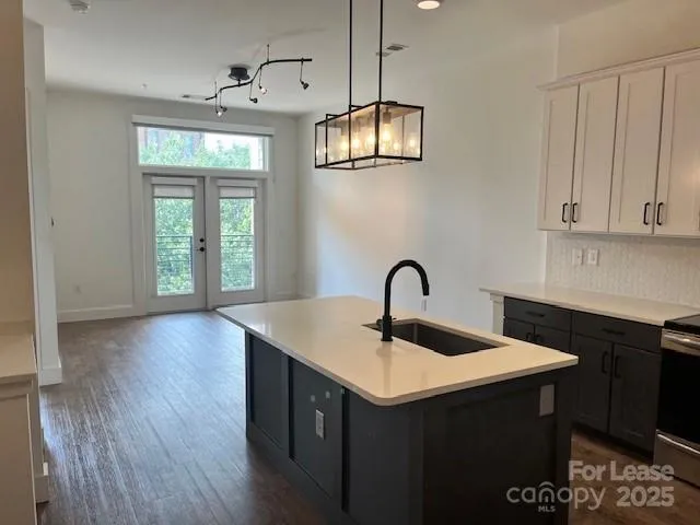 a kitchen with a sink cabinets and wooden floor