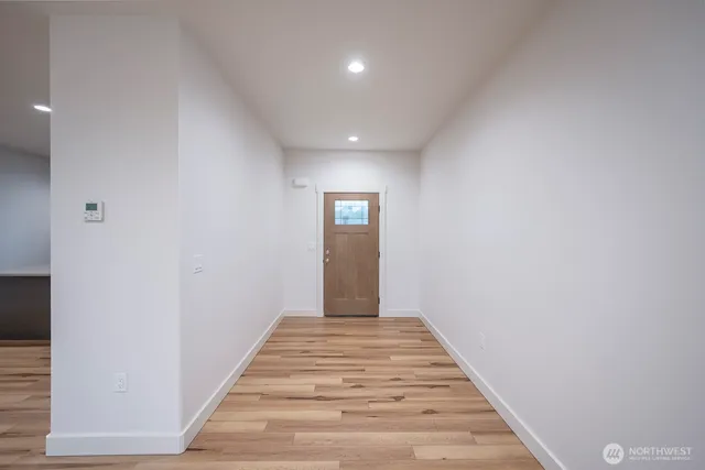 a view of a hallway with wooden floor
