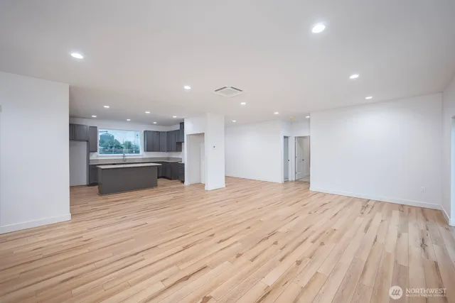 a view of kitchen with kitchen island wooden floor and center island