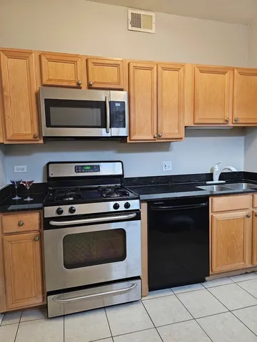 a kitchen with stainless steel appliances granite countertop a stove and a microwave