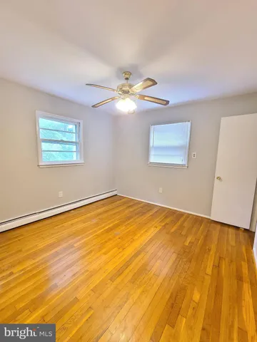 a view of a room with a wooden floor and a ceiling fan